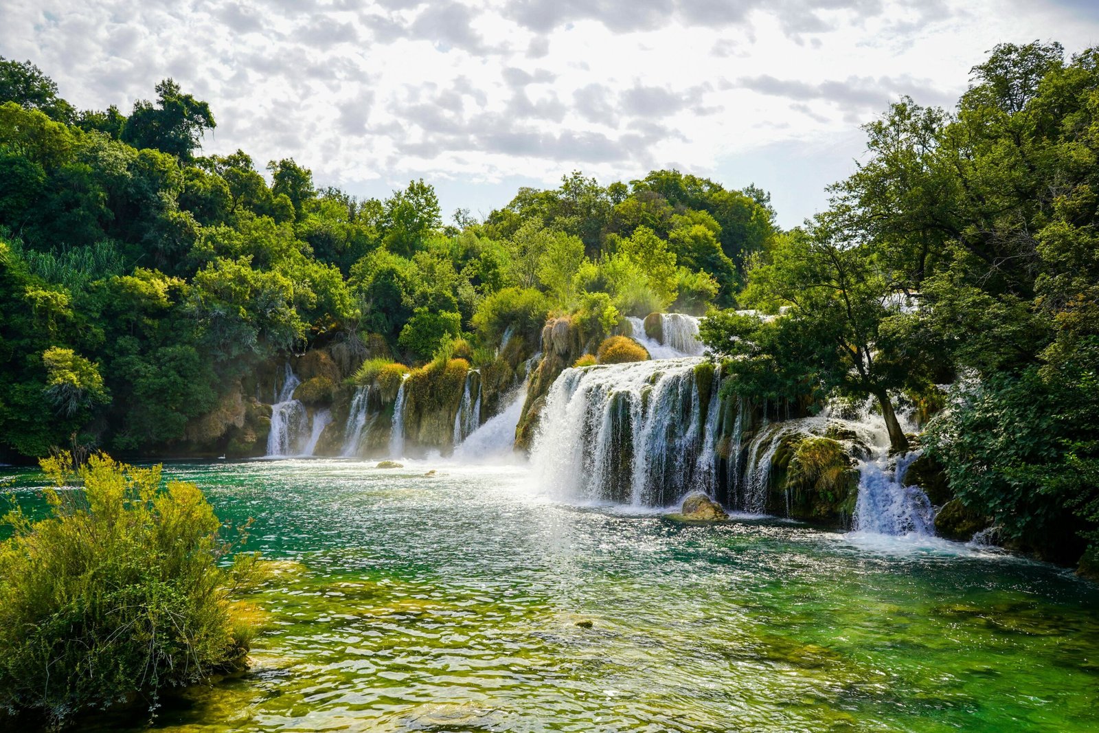 The stunning waterfalls of Krka National Park, surrounded by lush greenery and crystal-clear waters